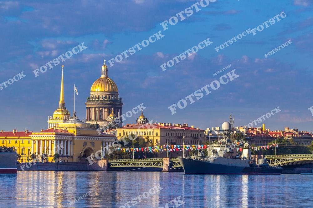 На этом фото запечатлен Исаакиевский собор в Санкт-Петербурге на фоне реки Невы летом. В кадре также виден Дворцовый мост и другие архитектурные достопримечательности города. Снимок отражает величие городской архитектуры, красоту мостов и панорамный вид на исторический центр Петербурга. Идеально подходит для туристических публикаций, коллекционеров и всех, кто хочет приобрести качественные фотографии северной столицы России. Отличный выбор для постеров, сувениров и использования в промо-материалах о Санкт-Петербурге.